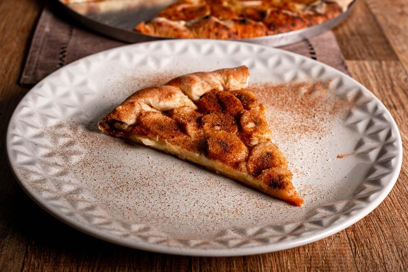 Sweet cinnamon dessert pizza with cream cheese drizzle